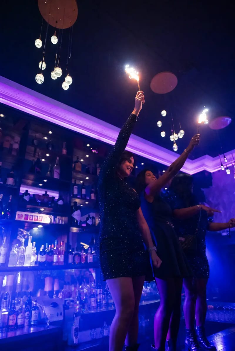 Clientes brandissant des fontaines d'étincelles devant le bar bleu