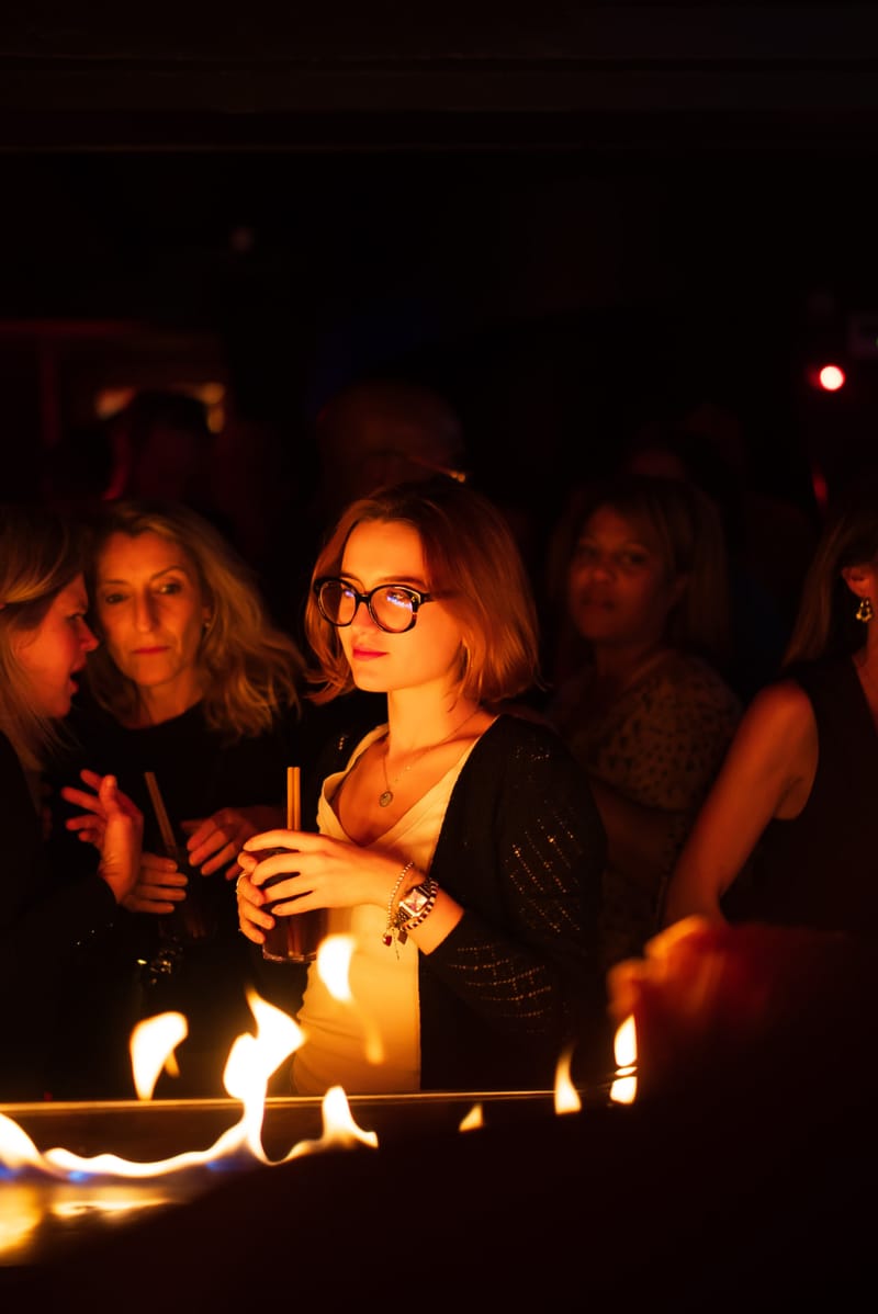 Cliente au bar derrière une ligne de flammes