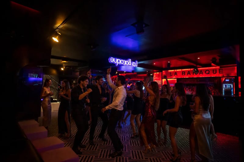 Piste de danse animée devant l'enseigne rouge La Baraque