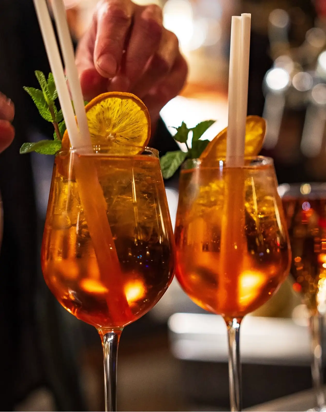 Deux spritz orange garnis d'orange séchée et de menthe