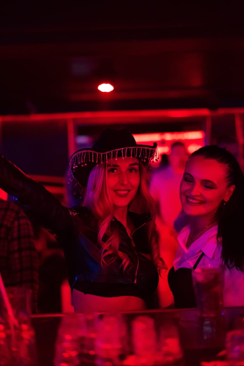 Clientes souriantes dans la lumière rouge du club